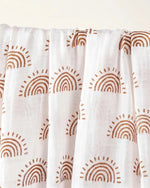 Muslin swaddle print in Aurora (white base, earth coloured rainbows)