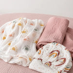 Peony Haze muslin swaddle and Sunbeam fitted cot sheet flat lay with minimalist sun print, birds eye view - Honey & Sage