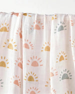 Muslin swaddle print in Soleil (white base, pastel suns)