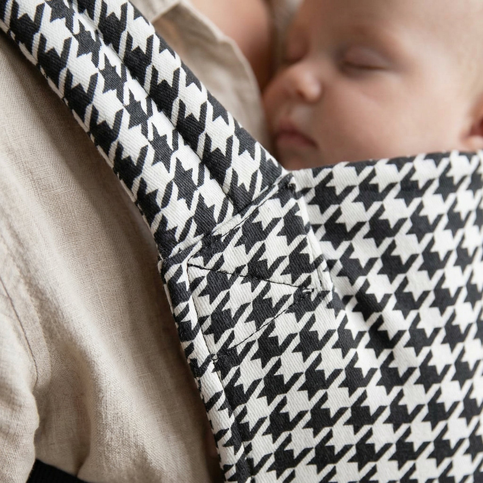 Black & white houndstooth onyx baby carrier worn by parent ergonomic front carry