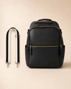 Black leather backpack with a shoulder strap on a beige background