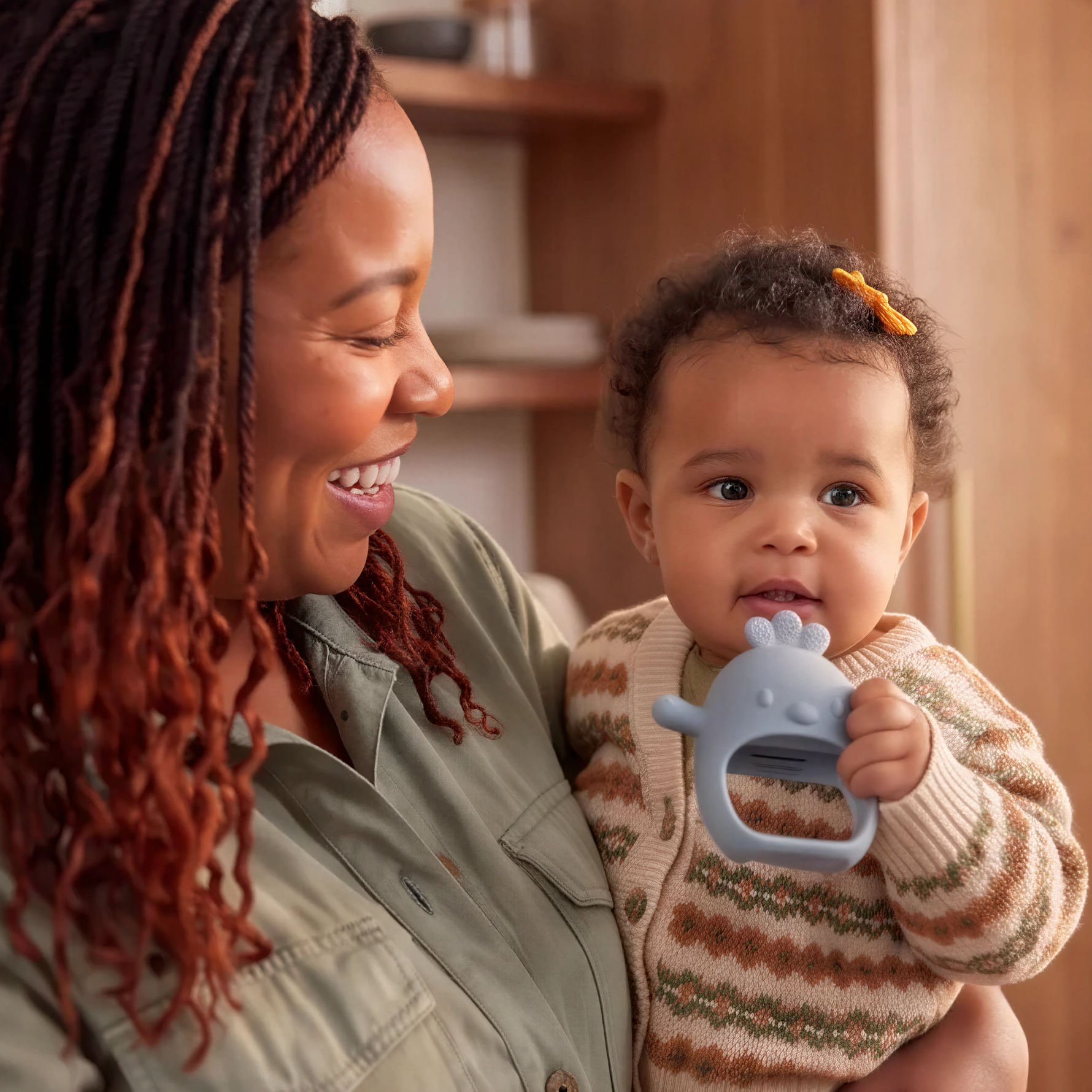 Baby holding Nest silicone teether in Kiama (blue)