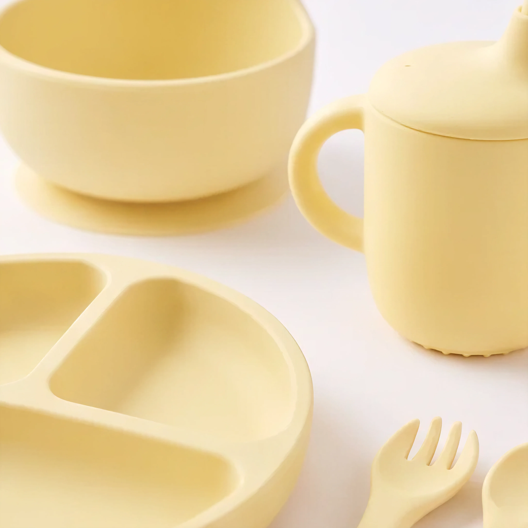 5 piece baby silicone feeing set in Dawn (bright yellow) with suction plate, sippy cup, suction bowl, fork and spoon