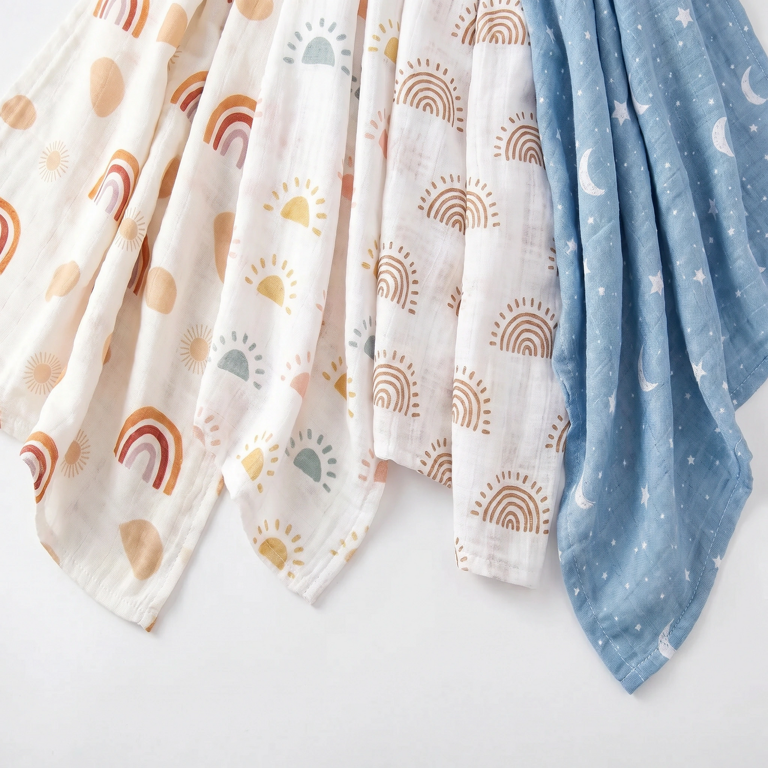 Product flat lay of muslin swaddle prints in lunar, Aurora, Soleil and Aurora colourways