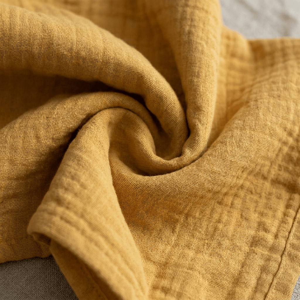 Honey Glow muslin baby swaddle, folded flat lay - Honey & Sage
