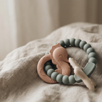 Muted green and peach silicone and wood baby teether 