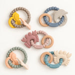 Reef silicone and beechwood baby teethers in assorted colourways, flat lay