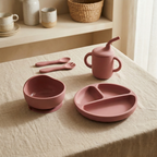 Rosewood pink children's dining set including bowl, plate, cups, and utensils on a neutral background.