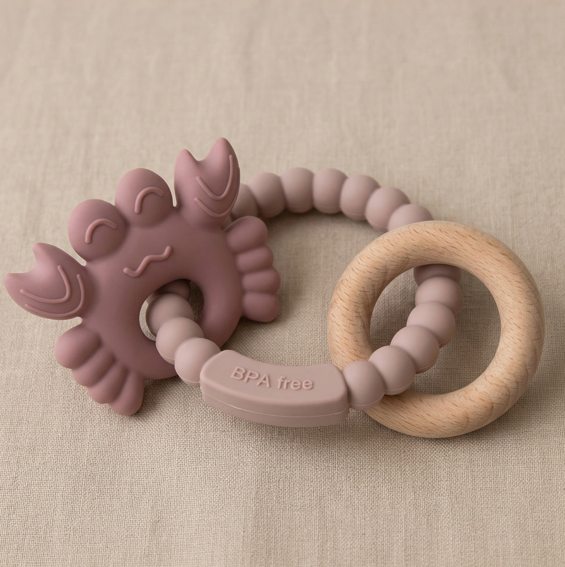 Soft pink silicone baby teether with beechwood ring