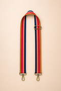 Rust berry toned interchangeable bag strap with gold hardware flat lay
